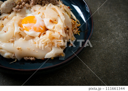 dried spicy noodles with minced pork, meatballs and egg 111661344