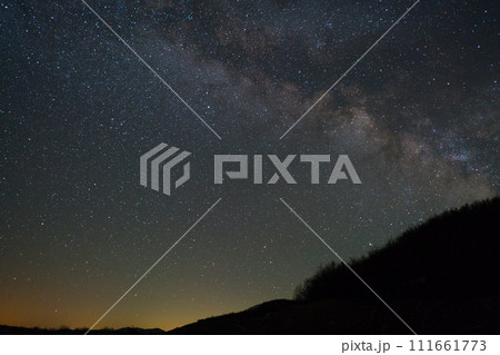 Milky way galaxy and a piece of hill with trees 111661773