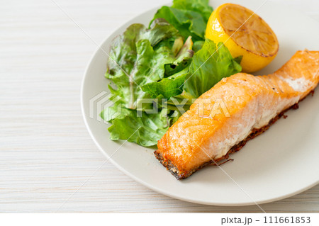 fried salmon steak with lemon and vegetable 111661853