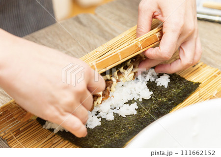 巻きすで巻き寿司を作る女性の手元 111662152