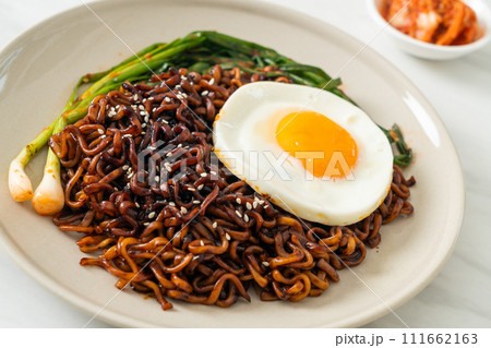 dried Korean spicy black sauce instant noodles with fried egg and kimchi 111662163