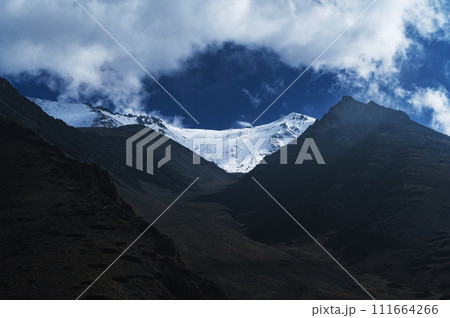 mountain peaks of glaciers with snow on the background of blue sky with clouds mountain peaks of glaciers with snow on the background of blue sky with clouds 111664266
