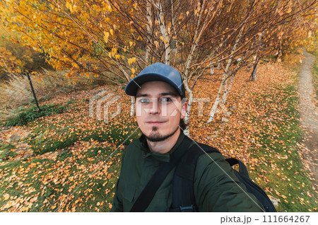 selfie of a male traveler tourist in autumn at orange autumn forest selfie of a male traveler tourist in autumn at orange autumn forest 111664267