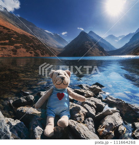 toy plush teddy bear sits relax on rocks near Koksay Lake in Kazakhstan in Tien Shan Mountains in autumn toy plush teddy bear sits relax on rocks near Koksay Lake in Kazakhstan in Tien Shan Mountains in autumn 111664268