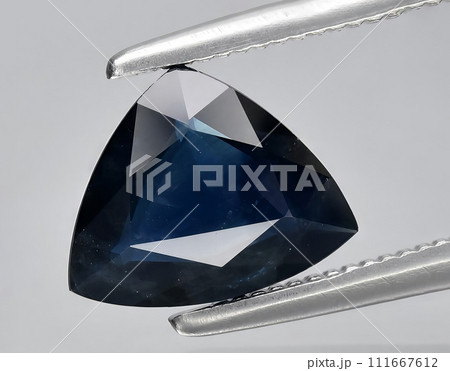 natural green blue sapphire gem on the background 111667612