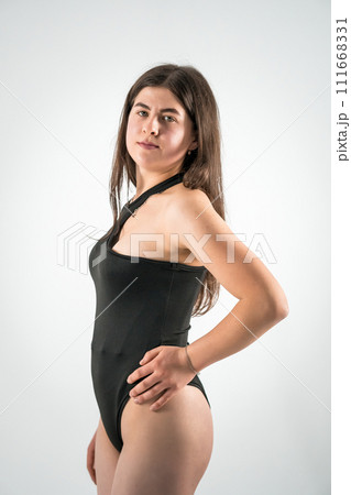 Beautiful young sexy girl in a black bodysuit on a white background 111668331