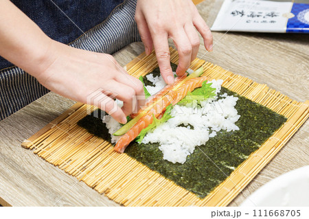 巻き寿司を手作りする主婦の手元 111668705