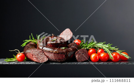 Traditional European black pudding or blood sausage with rosemary and tomatoes. 111668811