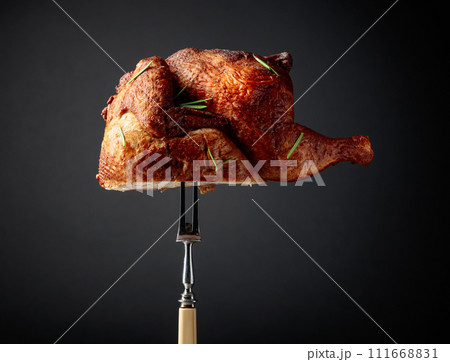 Smoked chicken on a fork sprinkled with rosemary. 111668831
