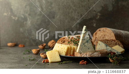 Cheese, bread, walnuts, and thyme on a stone kitchen table. Cheese, bread, walnuts, and thyme on a stone kitchen table. 111668837