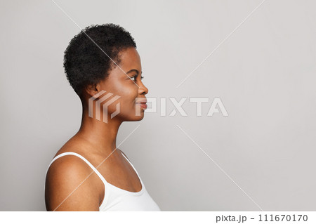 Female profile of healthy young woman with dark shiny skin smiling on white background.  111670170