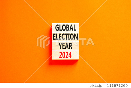 Global election year 2024 symbol. Concept words Global election year 2024 on beautiful wooden block. Beautiful orange table orange background. Business Global election year 2024 concept. Copy space. 111671269