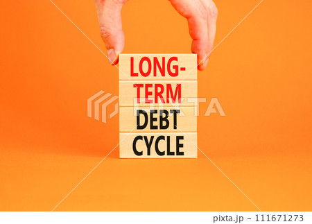 Long-term debt cycle symbol. Concept words Long-term debt cycle on beautiful wooden block. Beautiful orange table orange background. Businessman hand. Business Long-term debt cycle concept. Copy space 111671273