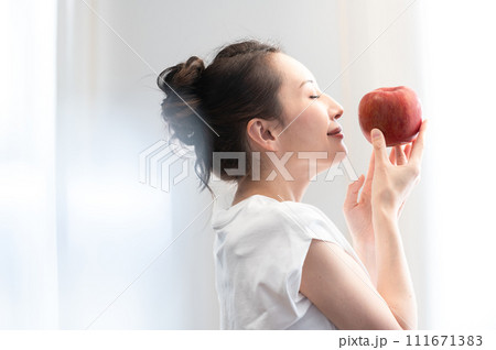 リンゴを手に持つ女性　ビューティーイメージ 111671383
