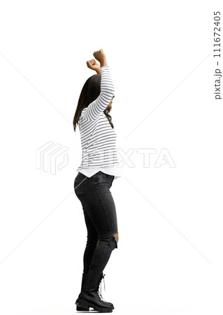 A woman, on a white background, in full height, raised her hands up A woman, on a white background, in full height, raised her hands up 111672405