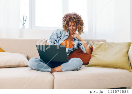 Happy Woman Working from Home on Laptop, Smiling in a Cozy Living Room 111673688