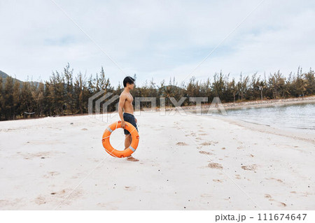 Guardian of the Sea: A Vigilant Asian Lifeguard Ensuring Safety and Rescue on a Lively Summer Beach Guardian of the Sea: A Vigilant Asian Lifeguard Ensuring Safety and Rescue on a Lively Summer Beach 111674647
