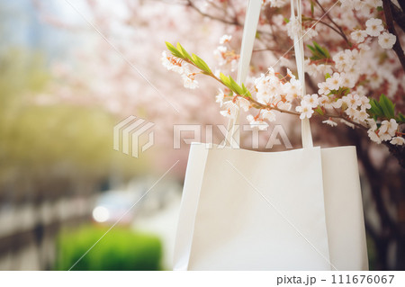 White blank shopping bag at spring cherry tree flowers background. Sale concept. AI Generative 111676067