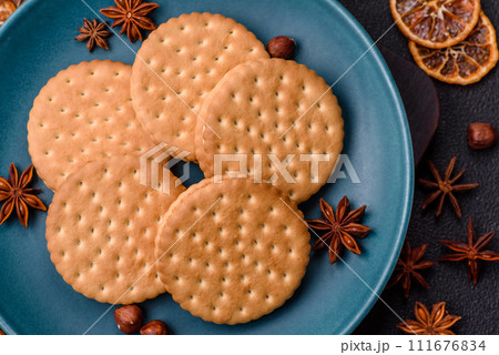Round dotted snack snack cookies with cream on a dark concrete background 111676834