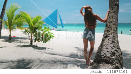 Woman relax on beach under coconut palm tree enjoy tropical island landscape. Boracay, Philippines. Yacht saining boats, turquoise water, blue sky. Outdoor lifestyle travel on summer holiday vacation 111678161