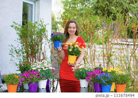 Beautiful young happy woman gardening outside in summer nature Beautiful young happy woman gardening outside in summer nature 111678494