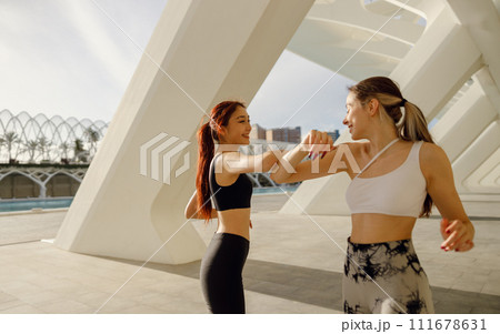 Sporty women non-contact greeting together outdoor meeting for fitness training or running outside 111678631