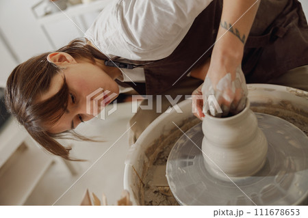 Professional female artisan shaping clay bowl in pottery studio. Ceramics art concept 111678653