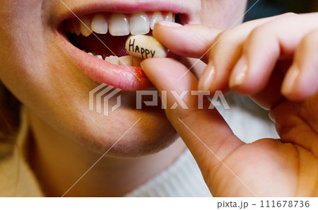 oval white tablet with the inscription happy in the mouth of a teenager oval white tablet with the inscription happy in the mouth of a teenager 111678736