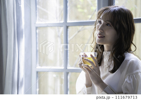 窓際で紅茶を飲む女性 111679713