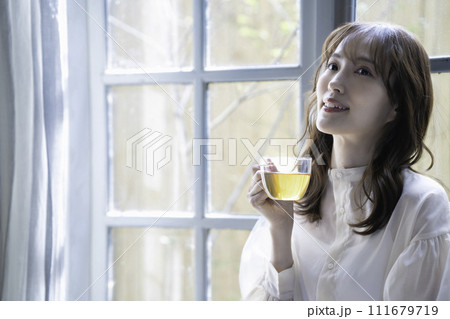 窓際で紅茶を飲む女性 111679719