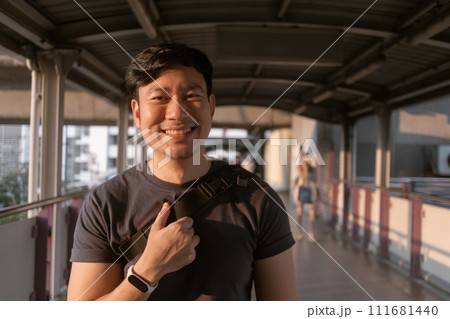 Happy ordinary man walk on the sky-train platform in Bangkok. Happy ordinary man walk on the sky-train platform in Bangkok. 111681440