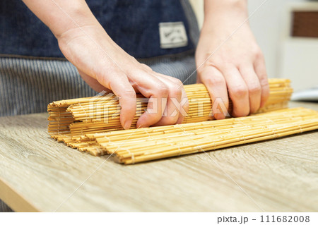 巻きすで巻き寿司を作る女性の手元 巻きすで巻き寿司を作る女性の手元 111682008
