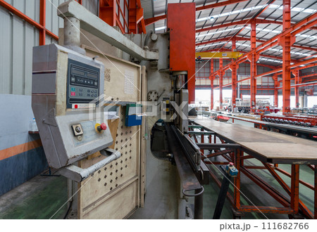A machine is being used in a factory to manufacture products. A machine is being used in a factory to manufacture products. 111682766