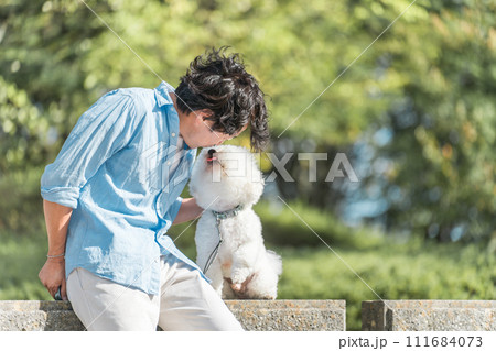 犬の散歩をする愛犬家の中高年男性・ドッグセラピー（キス・舐める・挨拶） 111684073