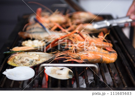 seafood barbecue on pan grilled by chacoal fire. Family bbq party seafood barbecue on pan grilled by chacoal fire. Family bbq party 111685683