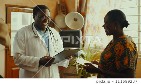 A smiling doctor holding a clipboard and discussing health plans with a patient, in a clinic flooded with daylight 111689237