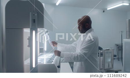 A surgeon reviewing a patient's X-rays on a lightbox in a clean, focused environment, preparing for a procedure 111689242