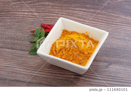 Yellow vibrant curcuma powder in the bowl Yellow vibrant curcuma powder in the bowl 111690101