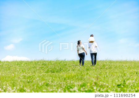 青空の草原を散歩する家族 111690254