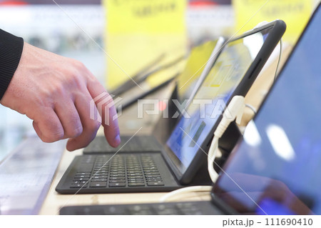 Buyer checking laptops in a computer store Buyer checking laptops in a computer store 111690410