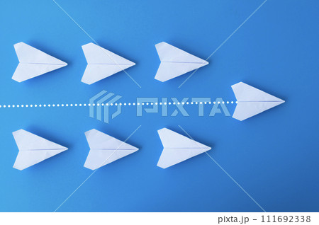 Top view of white paper airplanes origami with one flying ahead against all airplanes 111692338
