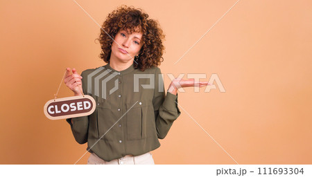 woman with closed sign on beige background woman with closed sign on beige background 111693304