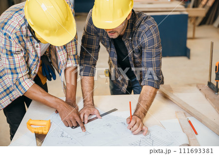 Two carpenter man wear meeting planning job together at carpentry workshop, craftsmen talking on construction plan blueprint, Happy Carpenter's Day 111693381
