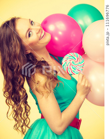 Woman with colorful balloons and lollipop Woman with colorful balloons and lollipop 111696776