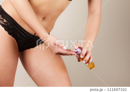 Woman applying moisturizing body oil lotion Woman applying moisturizing body oil lotion 111697102