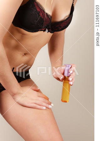 Woman applying moisturizing body oil lotion Woman applying moisturizing body oil lotion 111697103