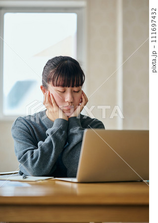 目を閉じて考え事をする若い女性 111697432