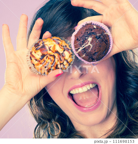 Smiling crazy woman holds cakes in hand 111698153