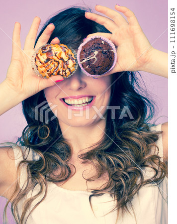 Smiling crazy woman holds cakes in hand 111698154