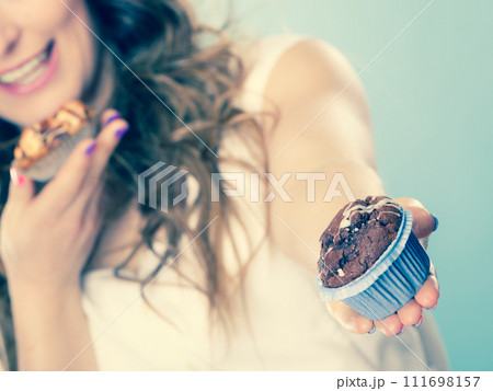 Smiling summer woman holds cakes in hand 111698157